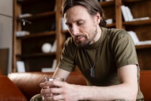 Persona reflexionando sobre los síntomas del alcoholismo y la importancia de buscar ayuda profesional